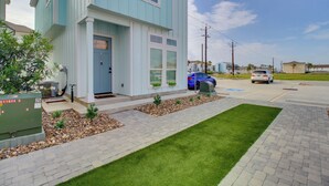A two-story house with a front porch, a driveway, and a well-maintained lawn. - Walk to Beach! North Padre Home w/ Pool Access (Corpus Christi)
