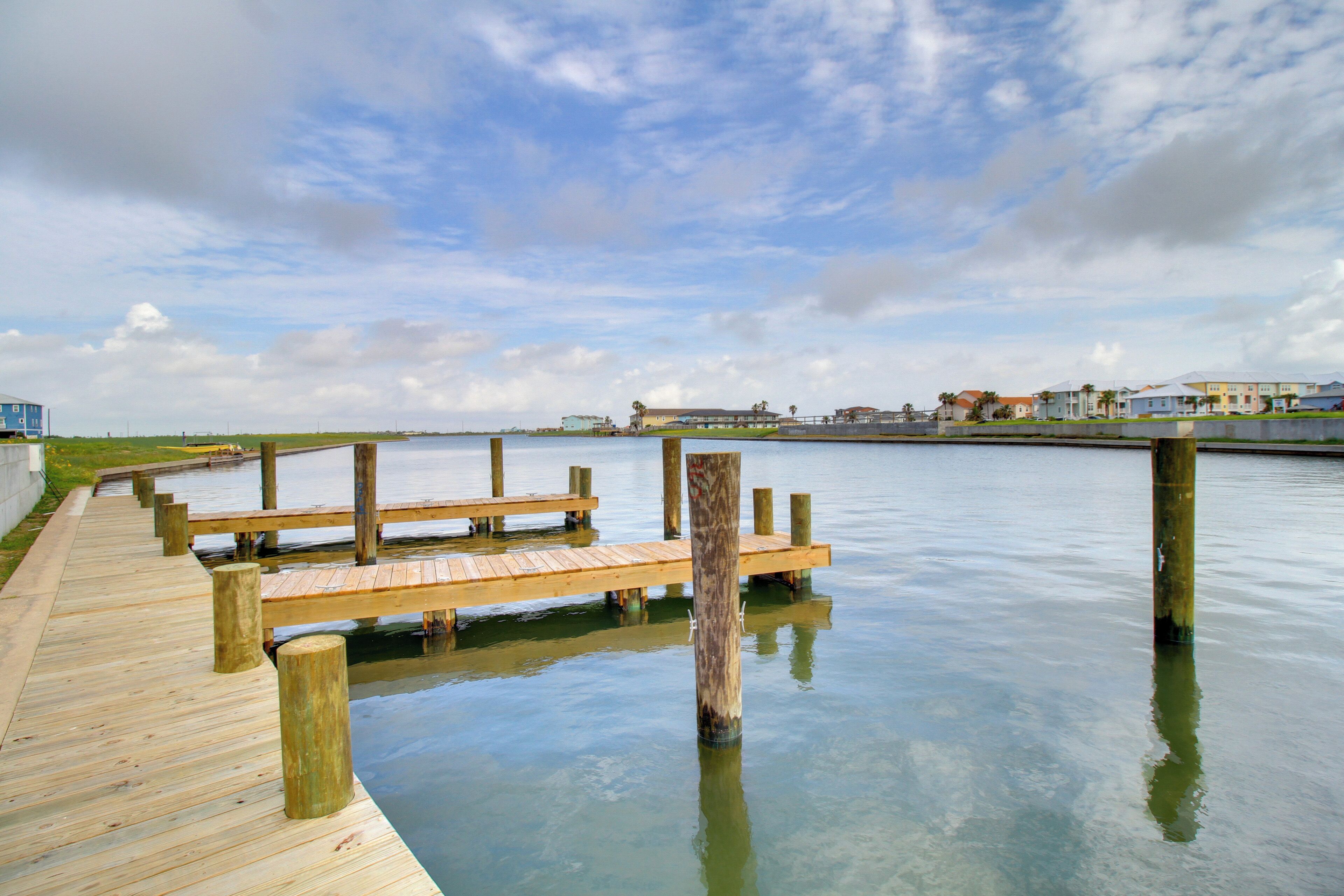 Un muelle de madera que se adentra en aguas tranquilas bajo un cielo despejado.