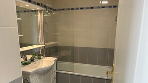 Un bagno con lavandino, specchio e vasca bianca.