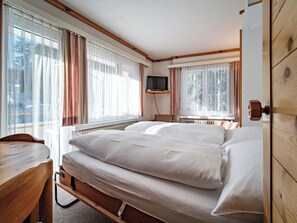 A bedroom with a bed, a desk, and a television. - Paradies 203 Appartement/Fewo,  , 3-Bettwohnung 3-Bettwohnung by Interhome (Arosa)