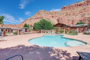 A pool area with lounge chairs, a wooden gazebo, and a mountain backdrop. - Red Rock Views, Pool Access! Zion Natl Park Base (Kanab)