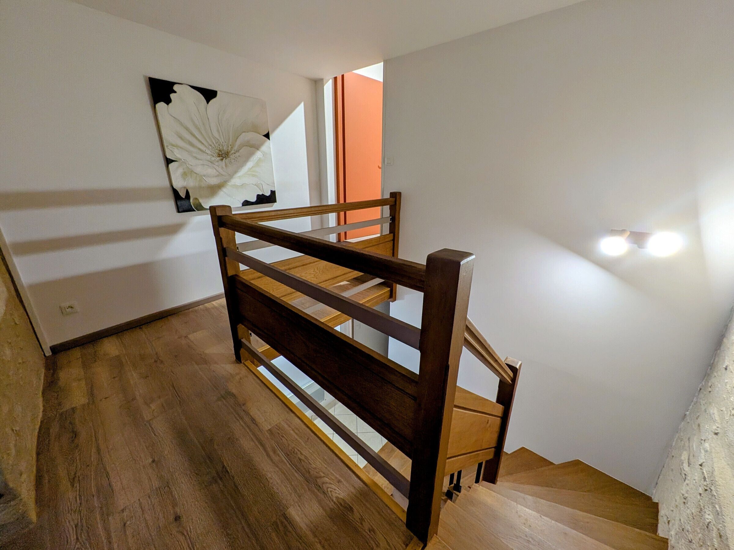 A wooden staircase with a handrail, leading to an upper floor.