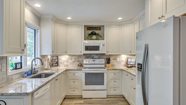 A kitchen with white cabinets, a built-in microwave, an oven, and a refrigerator. - Walk to Golf! Relax With Hot Tub and Game Room! (Pinehurst)