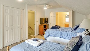 A bedroom with two beds, a TV, and a wooden cabinet. - Walk to Golf! Relax With Hot Tub and Game Room! (Pinehurst)