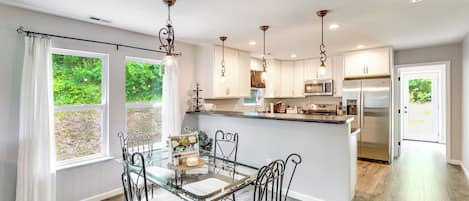 Una cocina moderna con comedor, ventanas amplias y vista a zonas verdes.