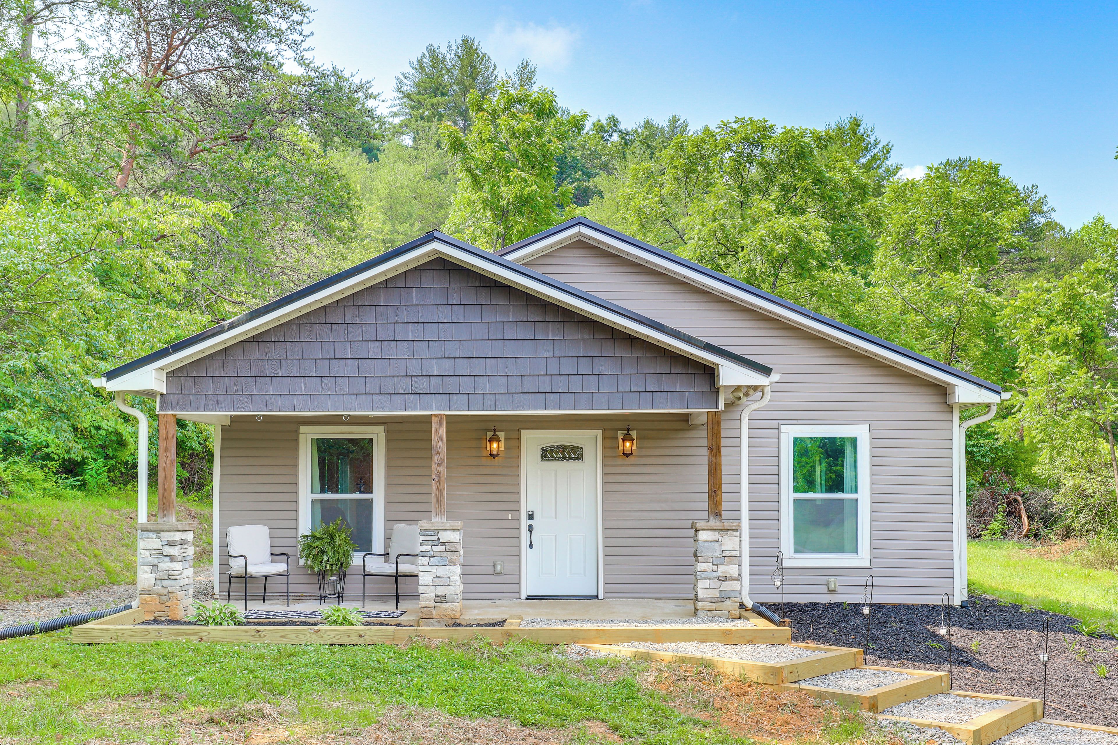 A single-story house with a front porch, a door, and two windows.