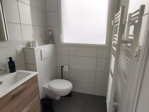 Un baño pequeño con inodoro, lavabo y espejo.