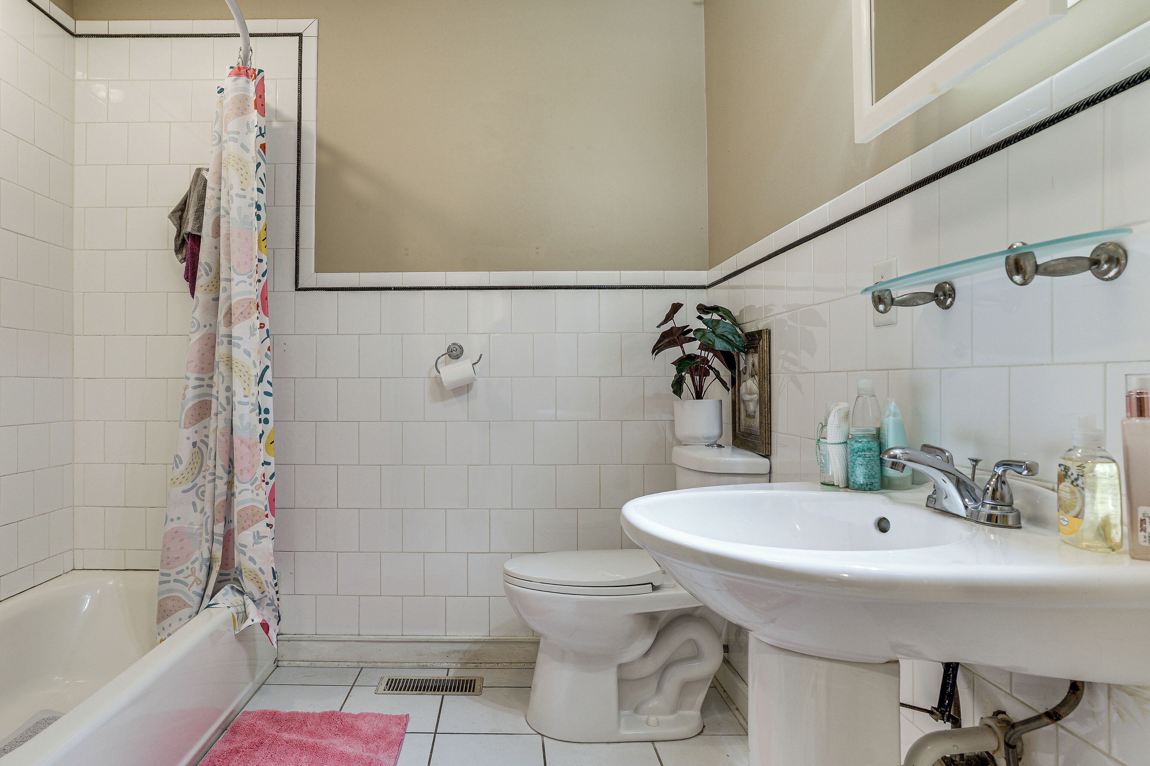 Un baño con bañera, inodoro, lavabo y cortina de ducha.