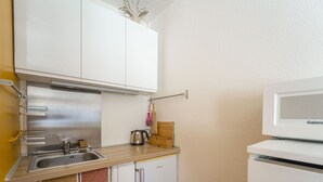 A compact kitchen with a sink, a kettle, a microwave, and a small refrigerator. - Charming studio at forest edge - 2 guests (Lit-et-Mixe)