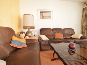 A living room with two brown leather sofas, a coffee table, a lamp, and a framed picture on the wall. - Gentiana C-7 Appartement/Fewo, Dusche und Bad, WC, 2-Bettwohnung by Interhome (Arosa)