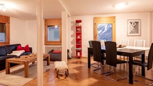 Una sala de estar acogedora con un sofá, una mesa de centro y un comedor con sillas y una mesa.