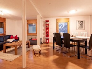 Ein gemütliches Wohnzimmer mit einer Couch, einem Couchtisch und einem Essbereich mit Stühlen und Tisch.