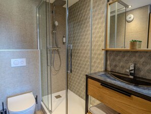 A modern bathroom with a glass shower enclosure, a wooden vanity, and a mirror. - Spacious apartment, close to slopes - 6 guests (Belle Plagne)