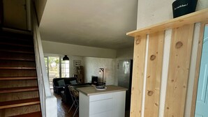 Eine Küche mit einer Holzinsel, einem Kühlschrank und einem Essbereich mit Tisch und Stühlen.