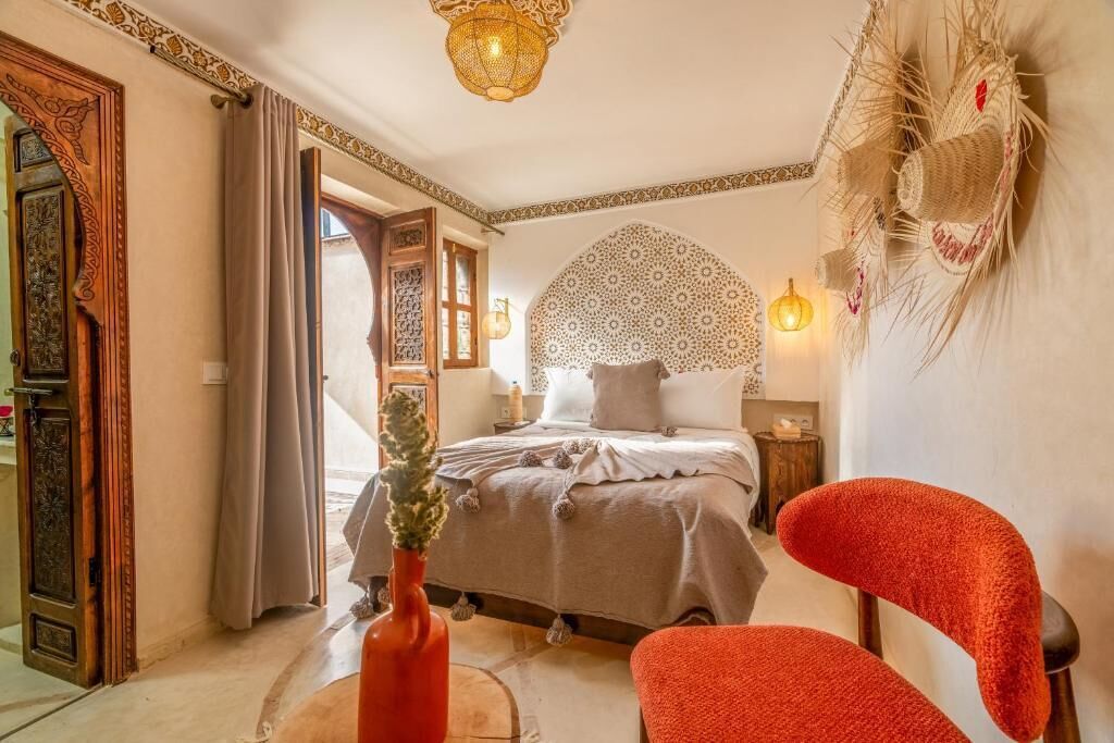 Une chambre à coucher avec un lit, une chaise, un mur décoratif et une porte.
