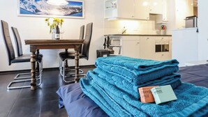 A modern room with a bed, a dining table, chairs, a kitchen area, and a painting on the wall. - Rothornblick 8 Appartement/Fewo, Bad, WC, 4-Bettwohnung by Interhome (Arosa)