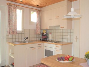 A kitchen with a sink, stove, and a fruit bowl on the counter. - Bisang S Appartement/Fewo,   4-Bettwohnung by Interhome (Arosa)
