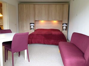 A compact room with a bed, a desk, and two chairs. - Bisang S Appartement/Fewo,   4-Bettwohnung by Interhome (Arosa)