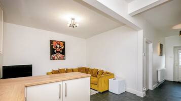 A modern living space with a sofa, a cabinet, a radiator, and a painting on the wall.