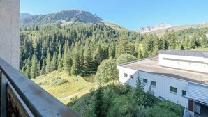 Vista de la montaña con un edificio en primer plano.