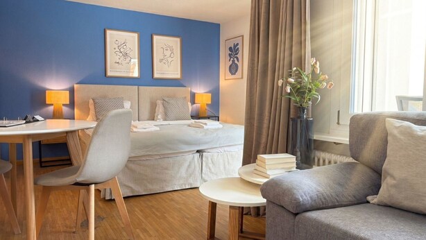 A hotel room with a bed, two bedside tables, a desk, a chair, and a sofa. - Waldhof 1 by Arosa Holiday Appartement/Fewo, Dusche, WC, 2-Bettwohnung Waldhof 1 by Interhome (Arosa)