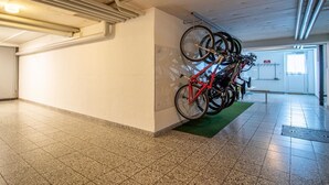 A hallway with a bike rack, a door, and a tiled floor. - Waldhof 1 by Arosa Holiday Appartement/Fewo, Dusche, WC, 2-Bettwohnung Waldhof 1 by Interhome (Arosa)