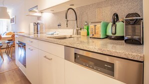 A modern kitchen with a stainless steel dishwasher, a granite countertop, and a coffee maker. - Rothornblick 57 by Arosa Holiday Appartement/Fewo, Bad, WC, 2-Bettwohnung by Interhome (Arosa)