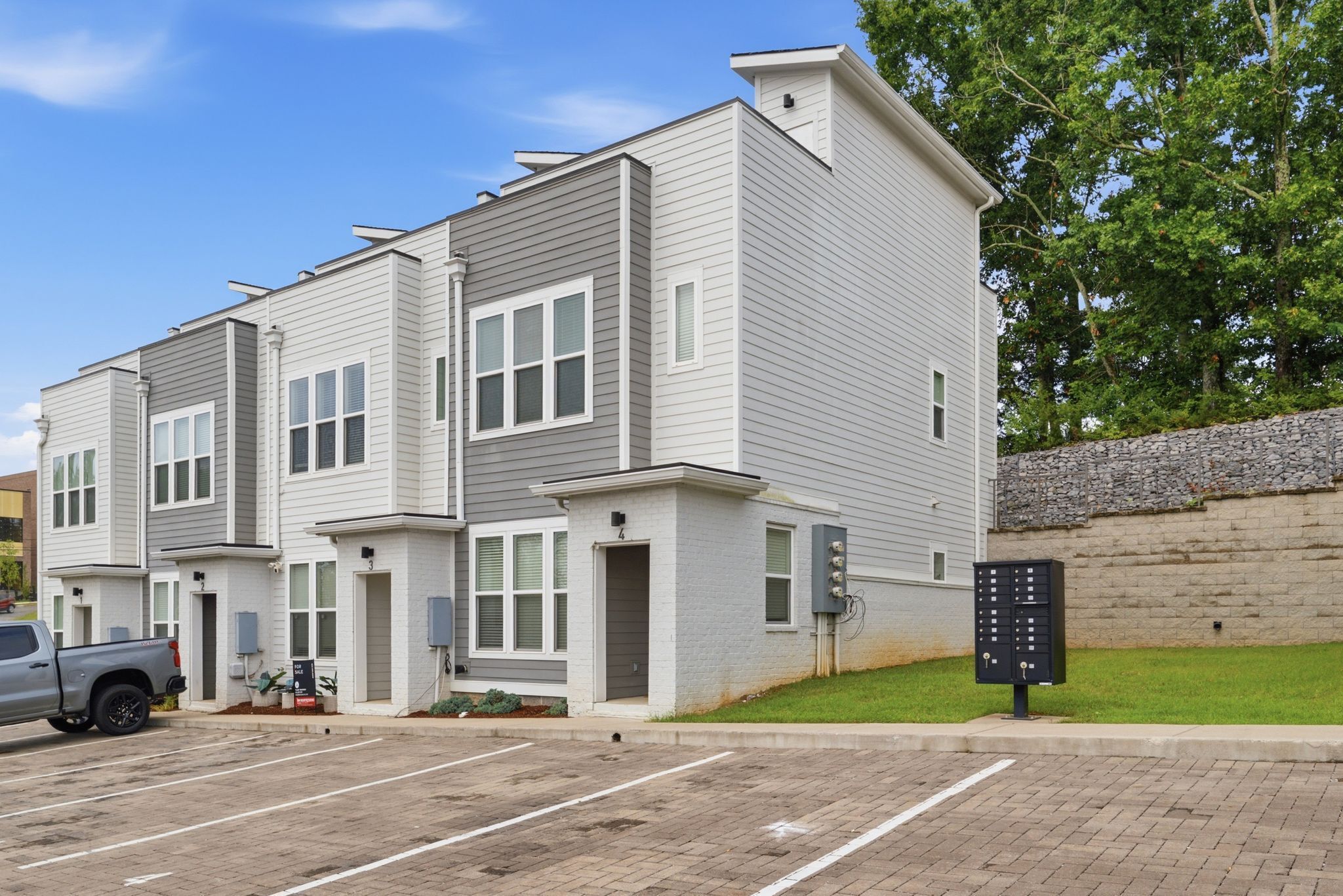 A multi-story residential building with a parking lot in front.