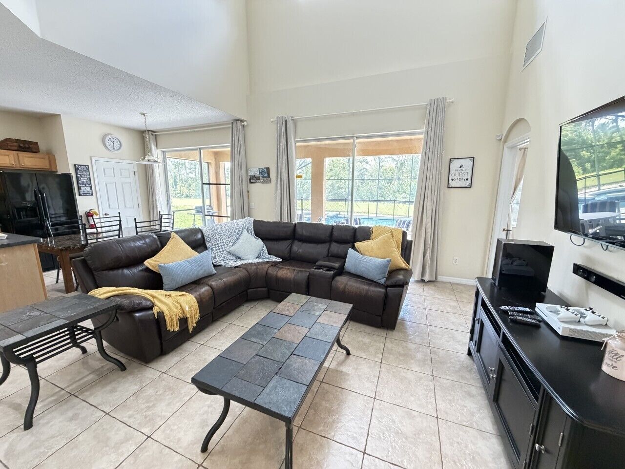 Ein Wohnzimmer mit Ecksofa, Couchtisch, Fernseher und Essbereich.