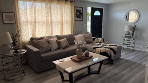 A living room with a sofa, coffee table, and a ceiling fan.