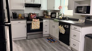 A kitchen with white cabinets, a stainless steel oven, a microwave, and a dishwasher.