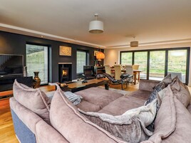 Una sala de estar moderna con chimenea, televisor y comedor.