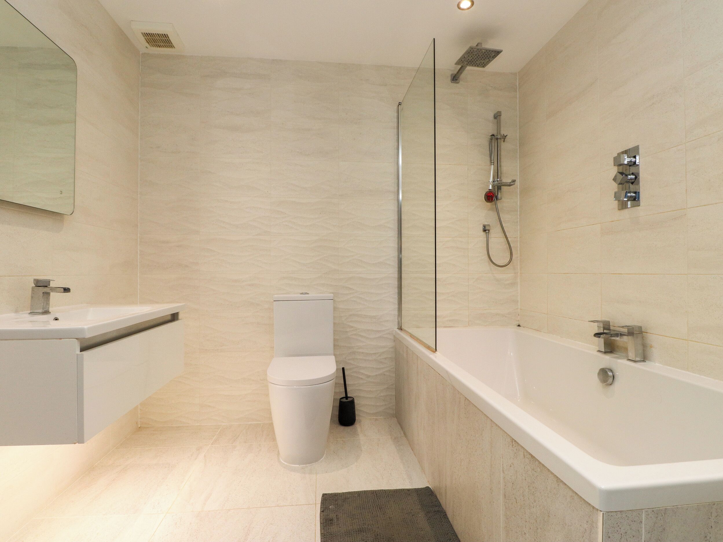 Un baño moderno con ducha, inodoro y lavamanos.