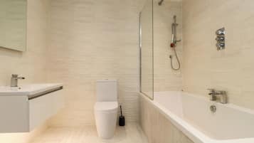 Un baño moderno con ducha, inodoro y lavamanos.