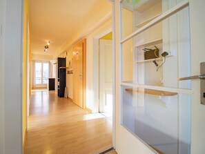 A hallway with wooden flooring, a glass door with a shelf, and a white wall with a power outlet. - Haldahus 2 by Arosa Holiday Appartement/Fewo,  , 7-Bettwohnung Haldahus 2 by Interhome (Arosa)