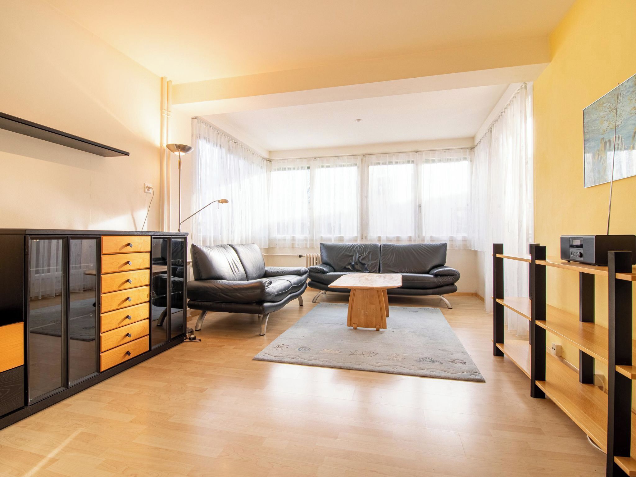 Un salon moderne avec un canapé, une table basse et un meuble.