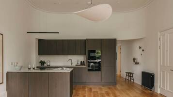 A modern kitchen with dark wood cabinets, a central island, and a built-in oven.