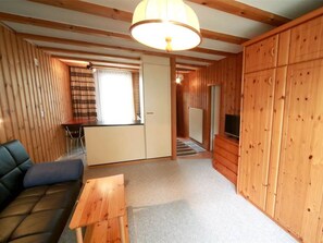 A wooden interior with a sofa, a table, a television, and a sliding door. - Hohl 2 Appartement/Fewo,  , 2-Bettwohnung 2-Bettwohnung by Interhome (Arosa)