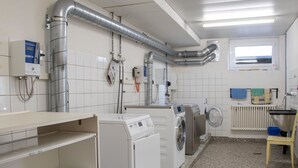 Une buanderie équipée de machines à laver, de sèche-linge et d’un radiateur.