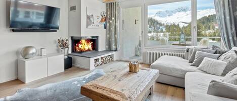 A modern living room with a fireplace, a television, and a sofa.
