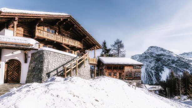 A wooden chalet with a stone facade, wooden balconies, and a staircase leading to the entrance. - Alpslodge Amelia Appartement/Fewo, Bad, WC, Terrasse by Interhome (Arosa)