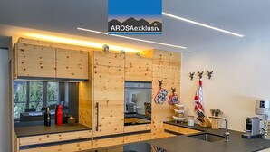 Eine moderne Küche mit Holzschnitzereien, einem eingebauten Ofen und einer Kaffeemaschine.