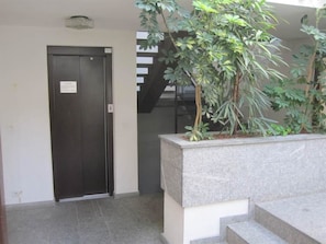 A closed door, a staircase, and a planter with green plants. - Villa Franca U01 Appartement/Fewo,   Villa Franca UO1 by Interhome (Arosa)