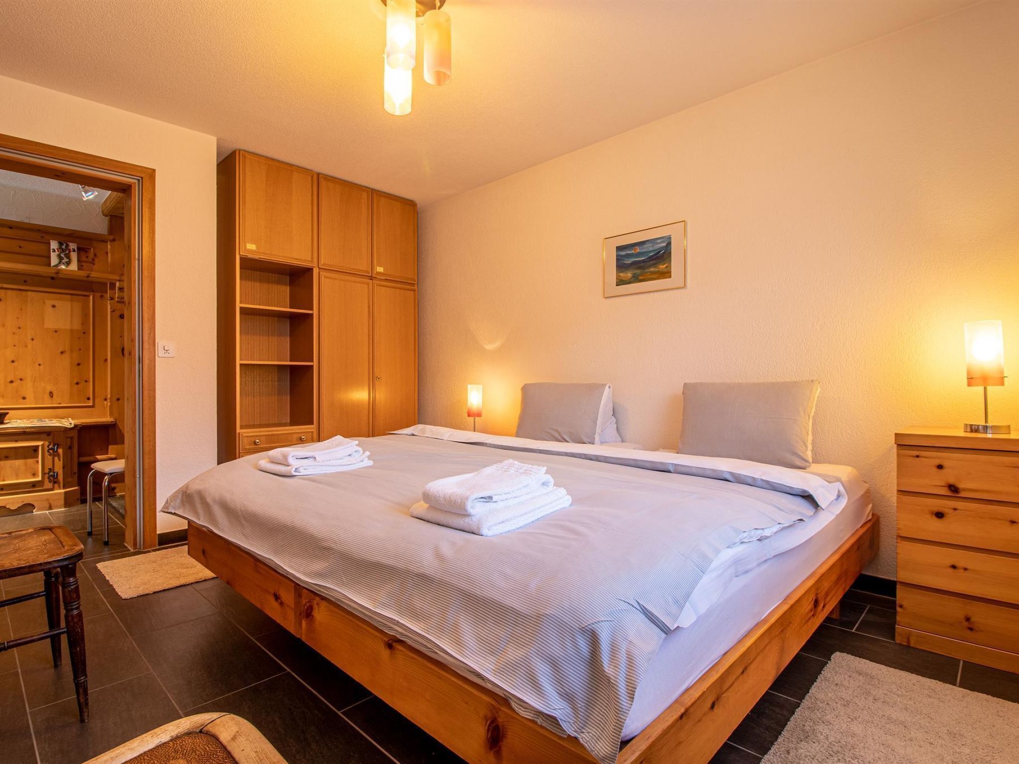 Ein Schlafzimmer mit Bett, Nachttischen, einem Kleiderschrank und einem Schreibtisch.