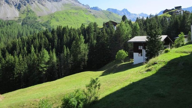 A mountainous landscape with a small building surrounded by dense forest and a clear sky. - Villa Franca U01 Appartement/Fewo,   Villa Franca UO1 by Interhome (Arosa)