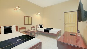 A hotel room with two beds, a desk, a chair, a TV, and a door. - Luxury Twin Stay With Free Wifi and Parking (Makassar)