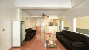 A spacious lobby with a glass coffee table, two black sofas, a refrigerator, and a ceiling fan. - Luxury Twin Stay With Free Wifi and Parking (Makassar)