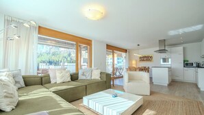 A modern living room with a sectional sofa, a coffee table, and a dining area with a chair. - Sunnaschy Heidi by Arosa Vacations Appartement/Fewo, Dusche und Badewanne, 2 Sch by Interhome (Arosa)