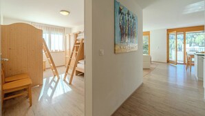 A spacious room with a wooden floor, a painting on the wall, and a view through a large window. - Sunnaschy Heidi by Arosa Vacations Appartement/Fewo, Dusche und Badewanne, 2 Sch by Interhome (Arosa)