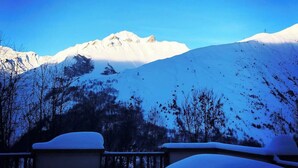 Paesaggio montano innevato con cielo sereno.